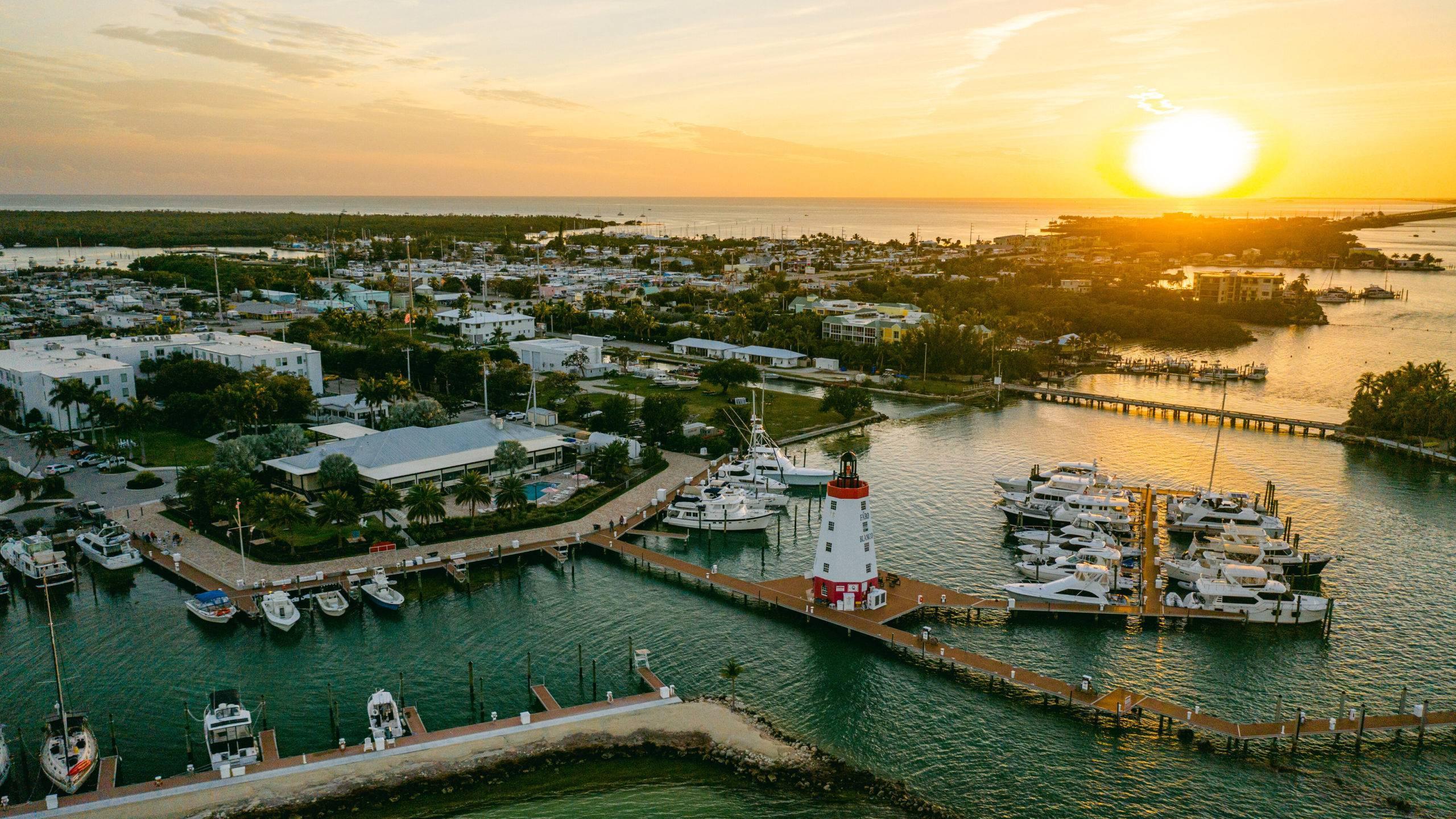 Illustrative Caribbean marina and sailboats in tropical waters